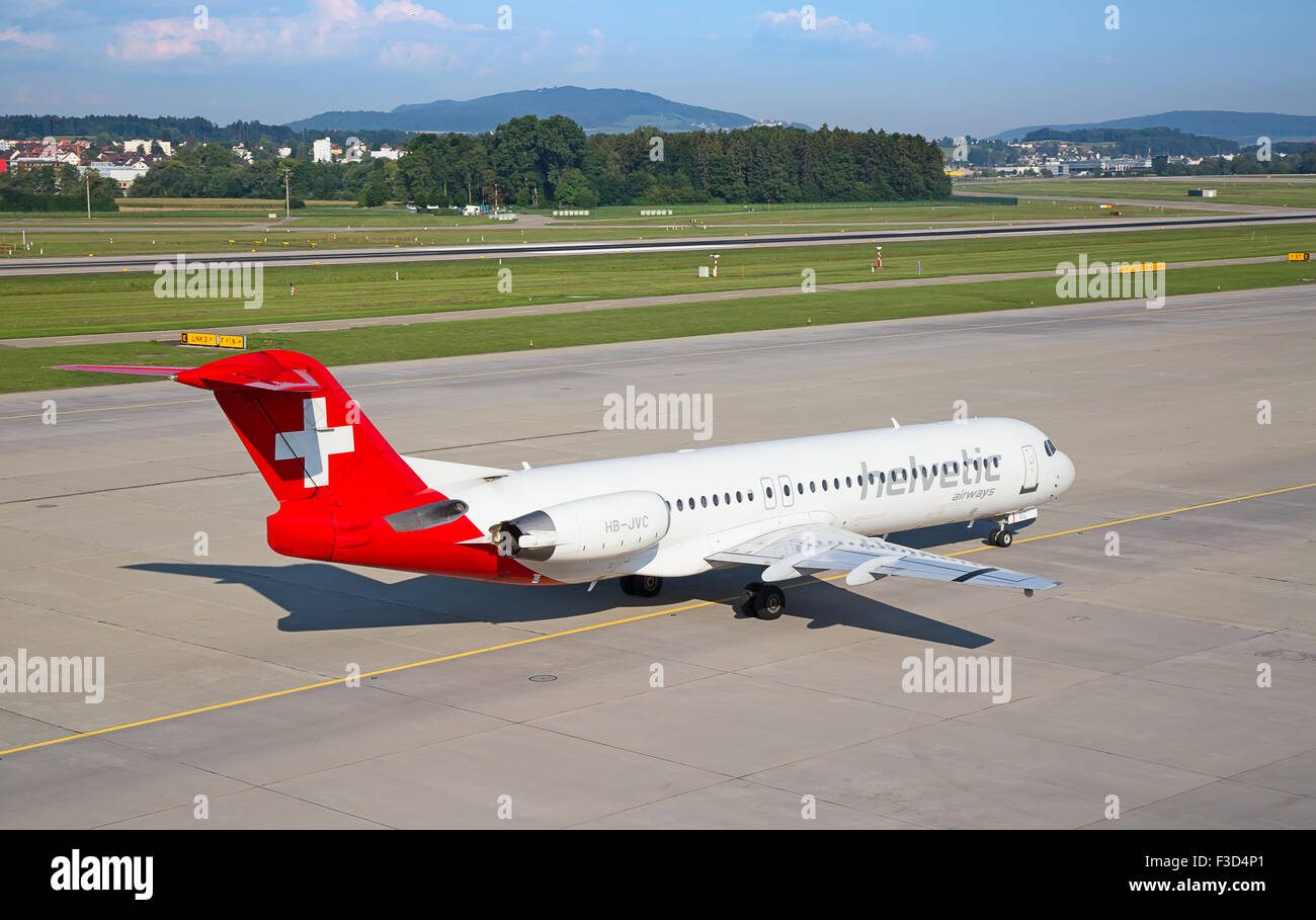 ZURICH - JULY 18: Fokker100 Helvetic airways taxing in Zurich after short haul flight on July 18, 2015 in Zurich, Switzerland. H Stock Photo