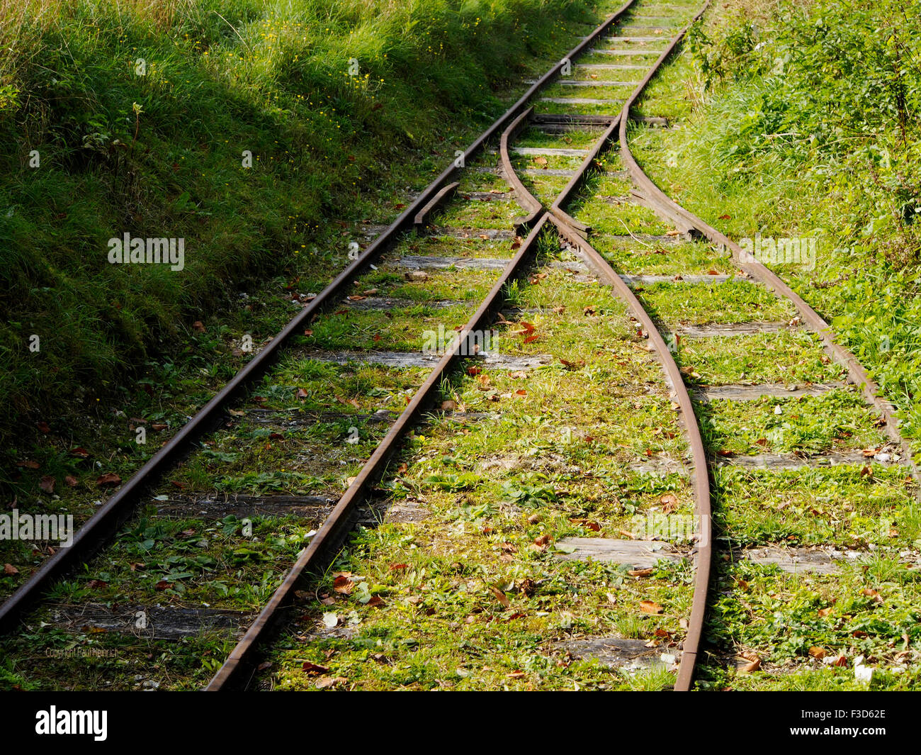 Keep on track - rusty industrial narrow gauge railway track with lines diverging at a point. Stock Photo