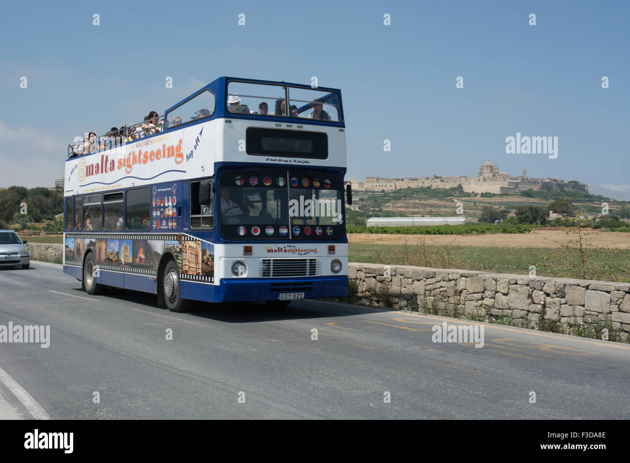A Volvo Citybus with Alexander bodywork travels towards the craft village at Ta'Qali. In the background is the city of Mdina Stock Photo