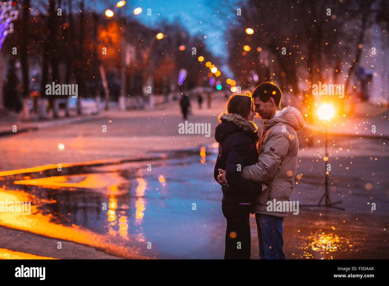 In love couple kissing in the snow at night city street. Filtered ...