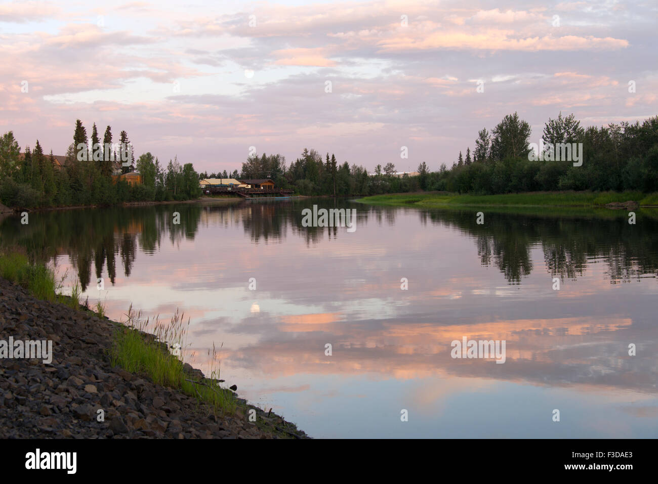 River Chena at midnight in Fairbanks, Alaska with moon reflected in
