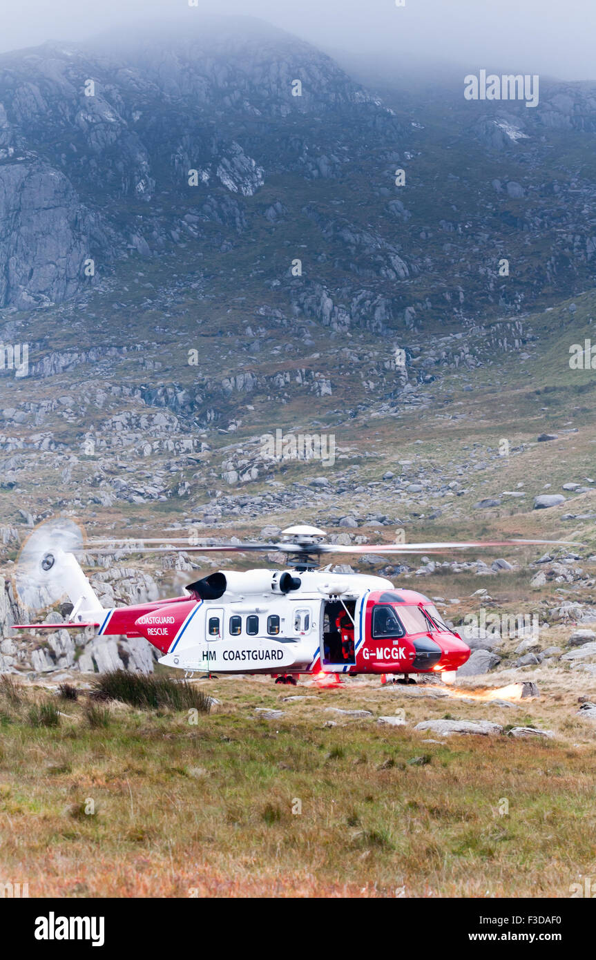 As dusk falls, the Coastguard Rescue Helicopter lands ready to assist a walker injured descending Tryfan Stock Photo