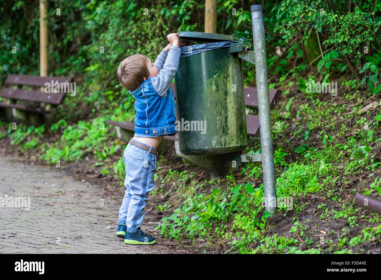 Little child throwing trash in the bin Stock Photo