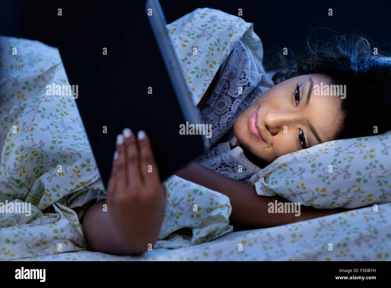 Young woman using tablet in bed Stock Photo
