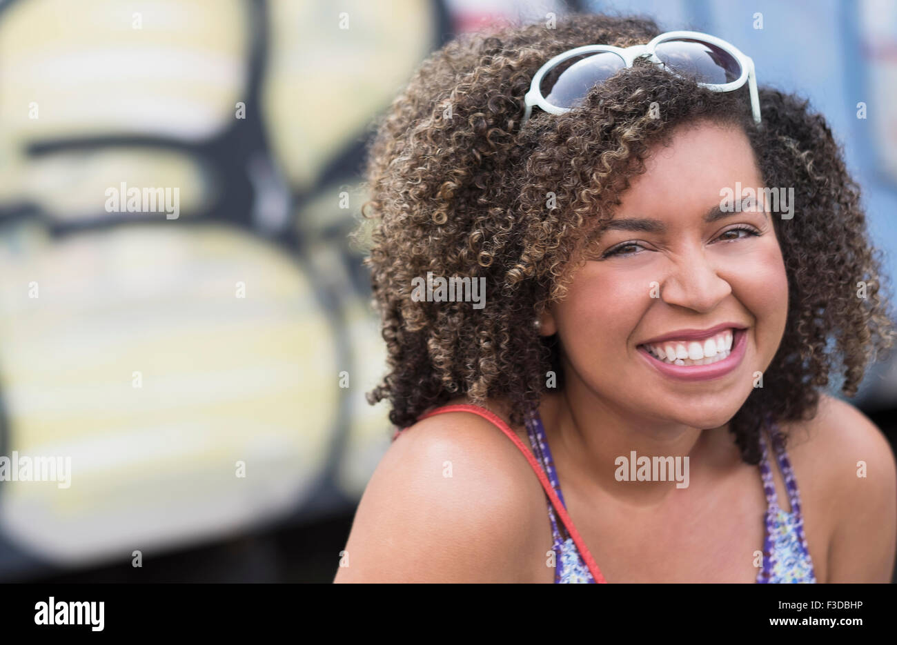 Portrait of smiling young woman with curly hair Stock Photo