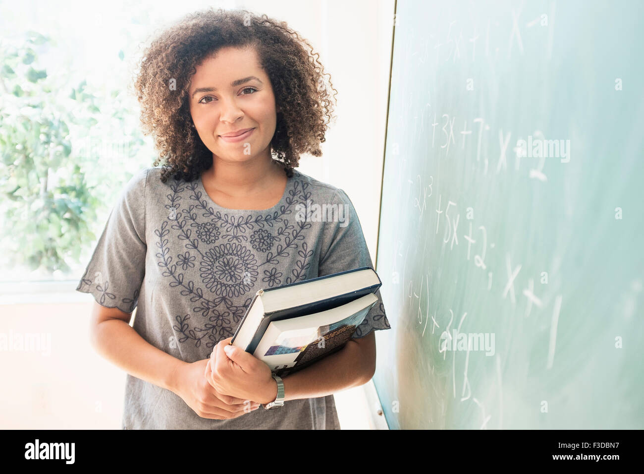 Portrait of young woman holding books Stock Photo - Alamy
