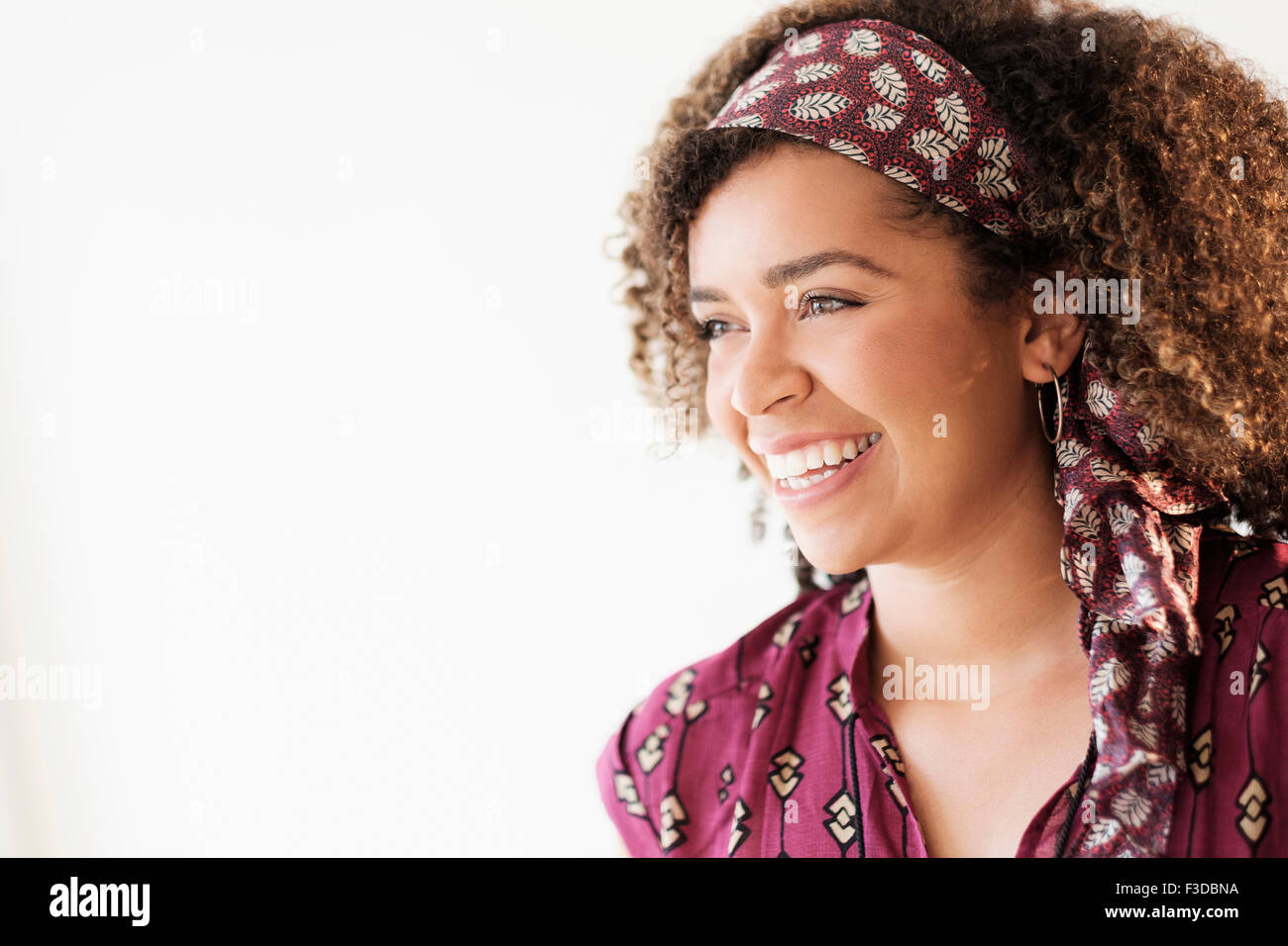 Portrait of smiling woman with curly hair Stock Photo - Alamy