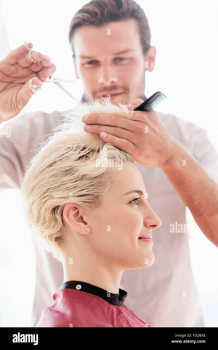 Hairdresser cutting woman's hair Stock Photo