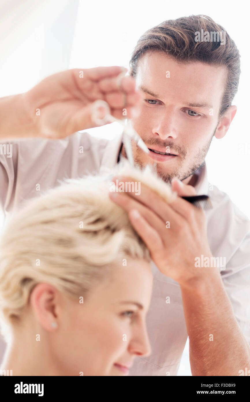 Hairdresser cutting woman's hair Stock Photo