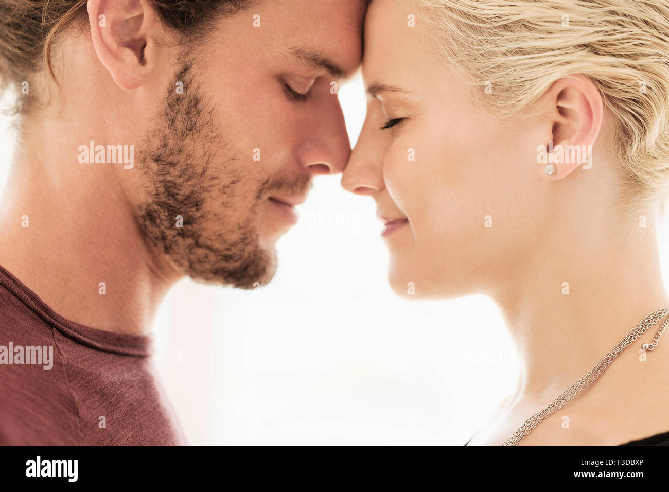 Couple rubbing noses on white background Stock Photo