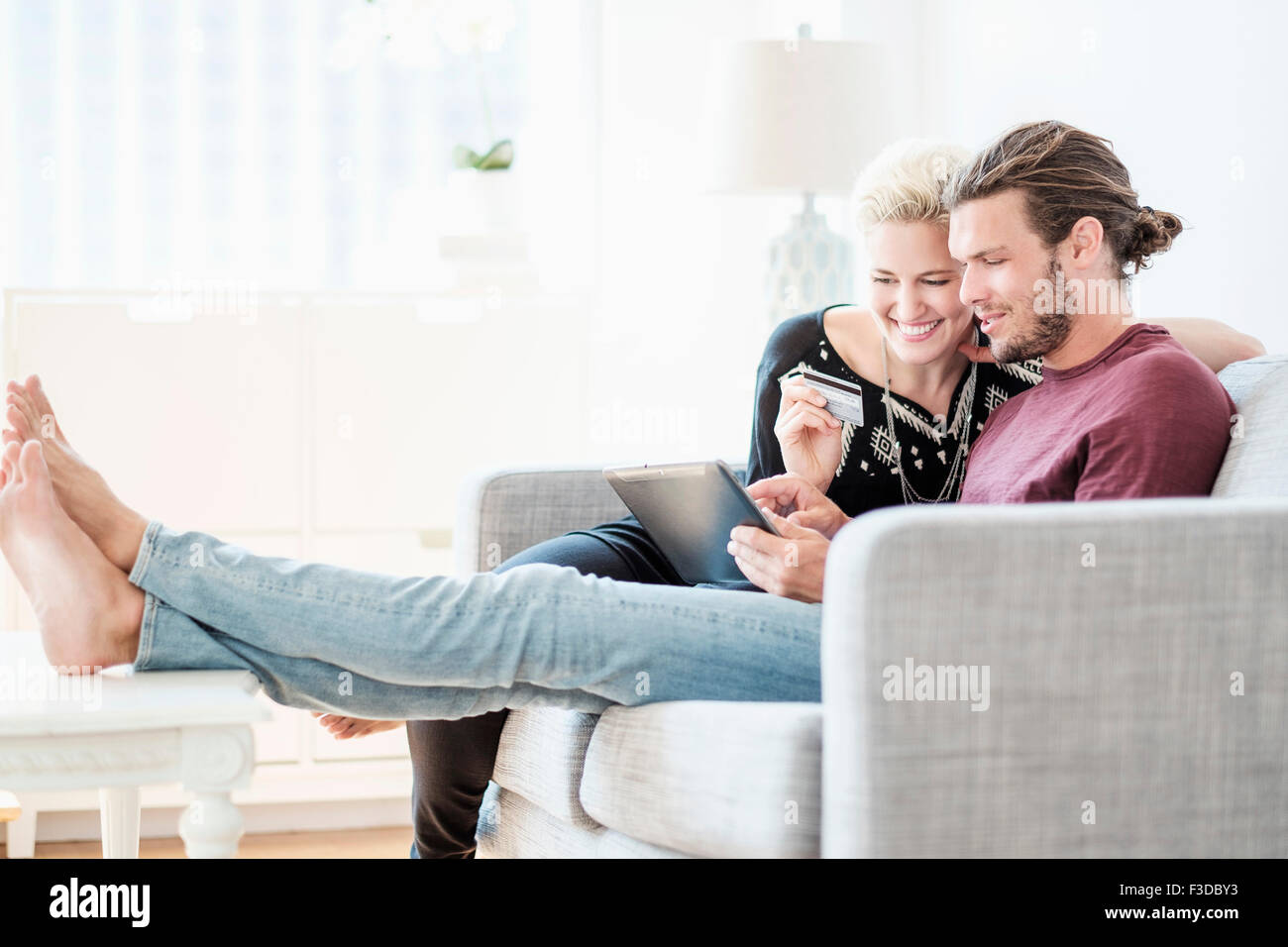 Couple using tablet pc on sofa Stock Photo