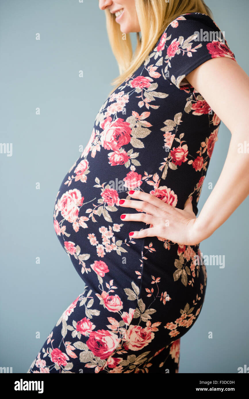 Studio shot of pregnant woman in floral dress Stock Photo