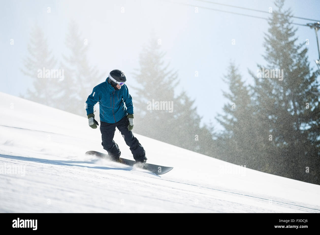 Man snowboarding downhill Stock Photo