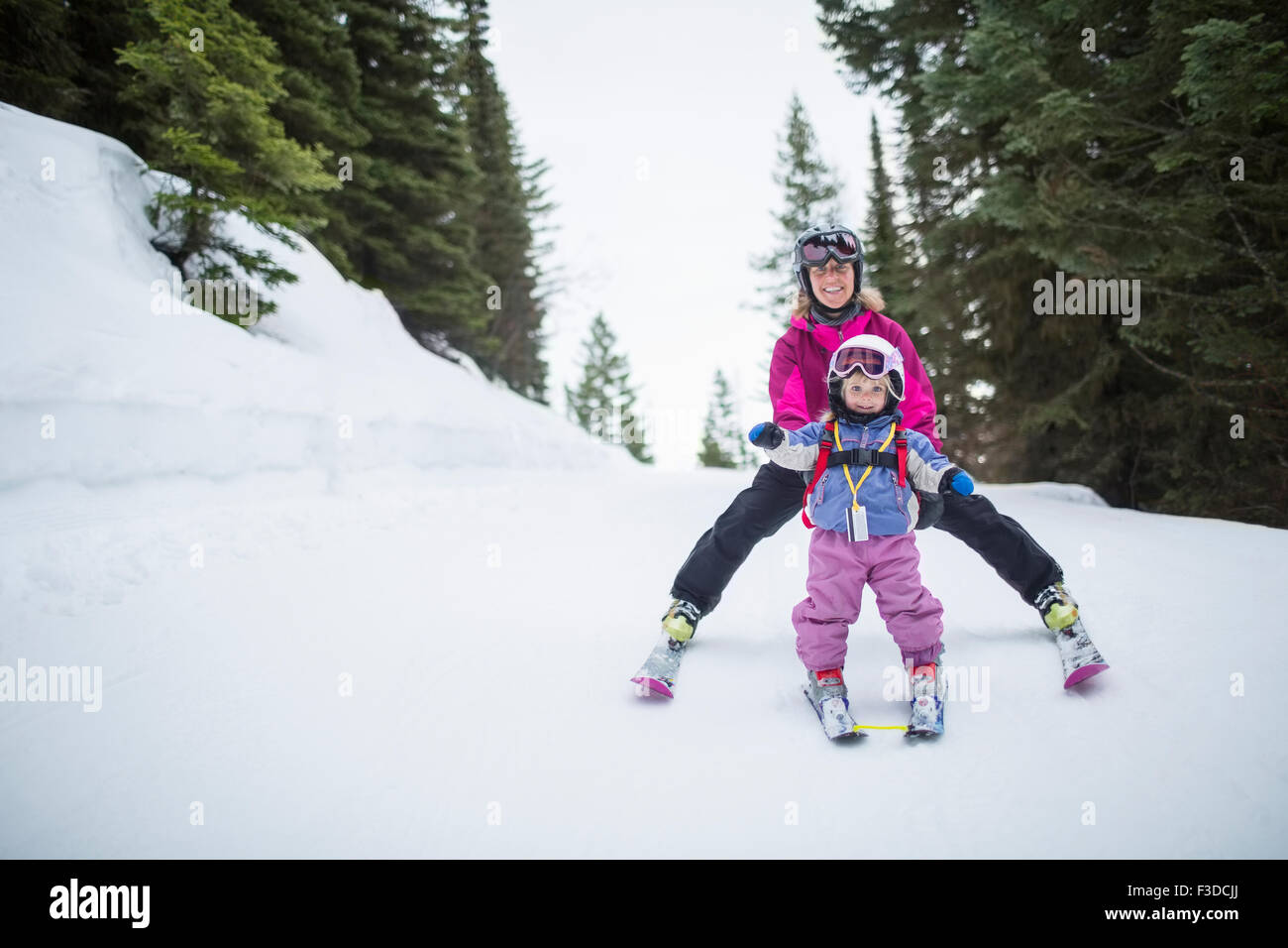 Little girl (2-3) learning skiing with mother Stock Photo