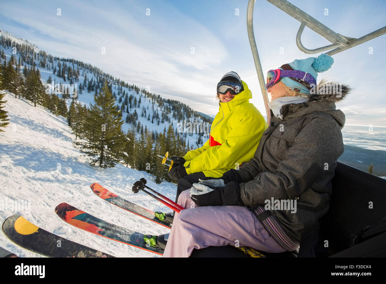 Couple in skiwear sitting on ski lift Stock Photo