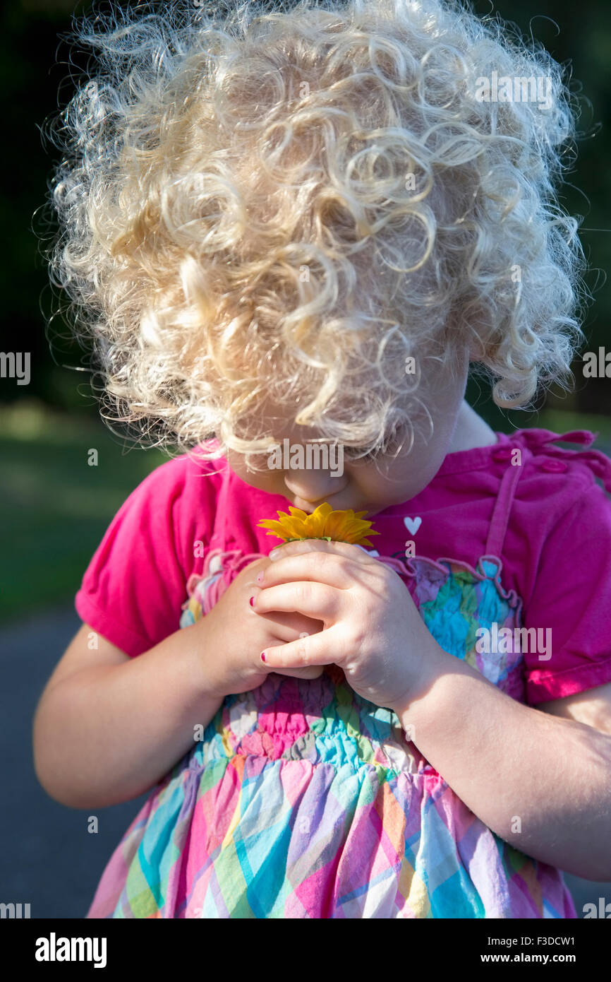 Portrait of young girl (4-5) smelling flower Stock Photo