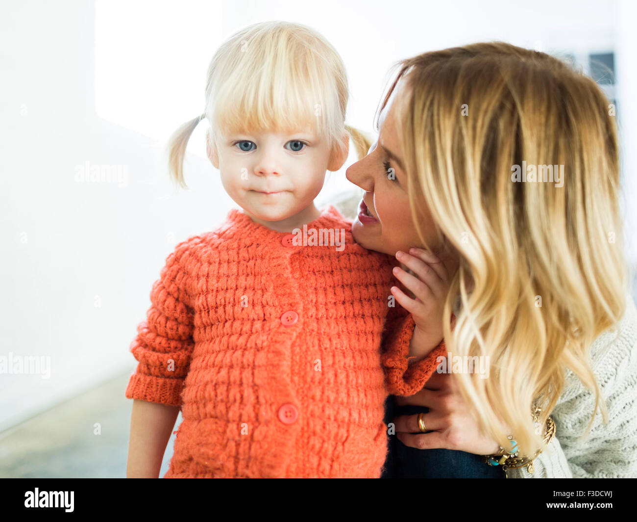 Cute girl (2-3) looking at camera with mother Stock Photo - Alamy