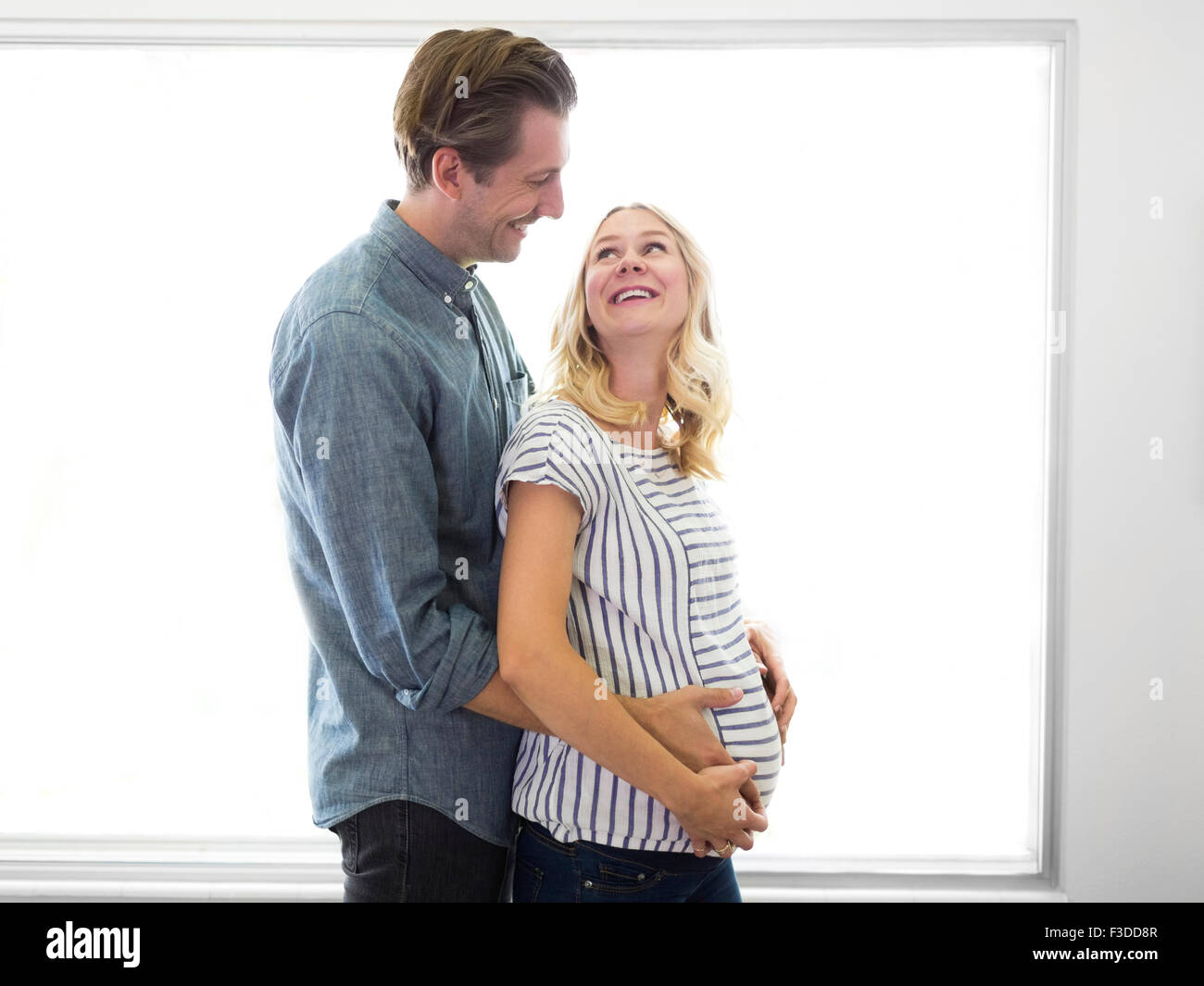 Husband embracing pregnant wife Stock Photo