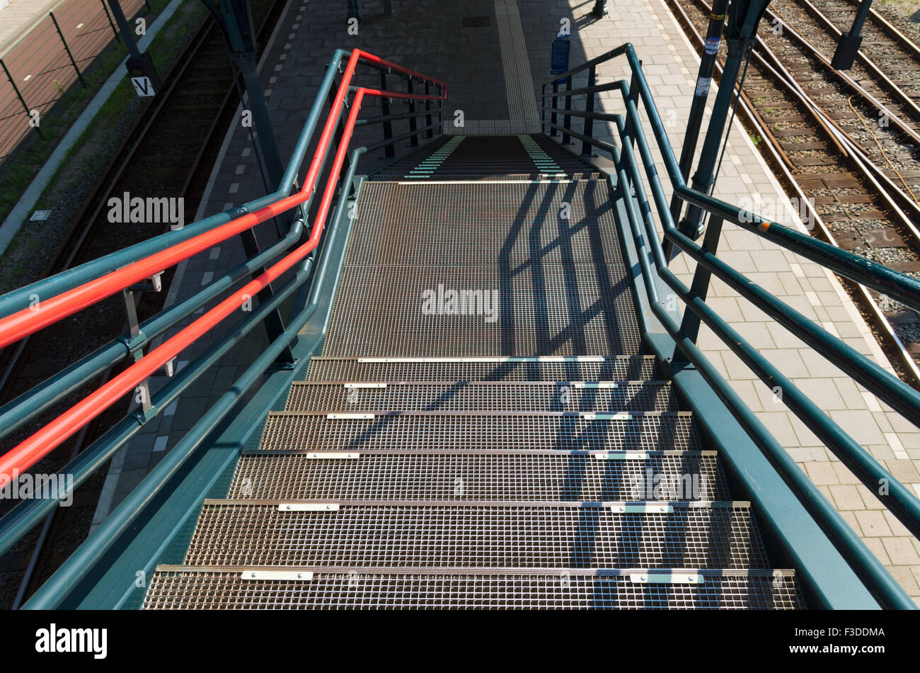 metal stairs leading down to a train platform Stock Photo