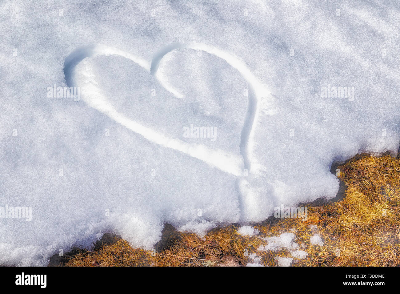 A heart drawn by hand in the fresh snow Stock Photo