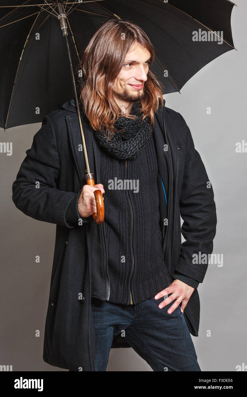 Portrait of handsome fashionable man wearing black coat and scarf ...