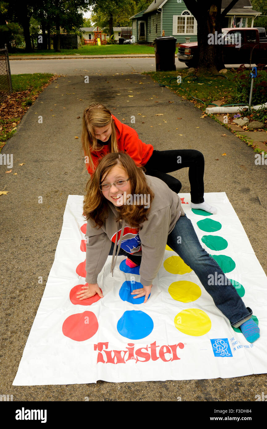 Teen and pre-teen girls playing Twister floor game. Stock Photo