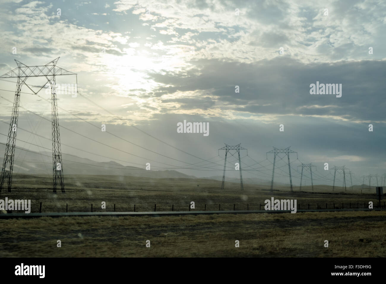 power lines in a rural field, cloudy sky Stock Photo - Alamy