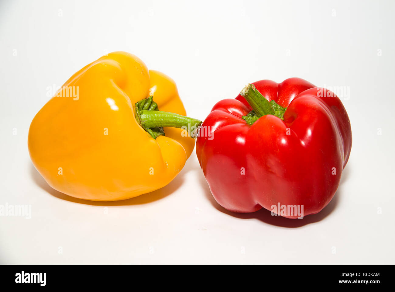 Two red and yellow peppers on a white background Stock Photo - Alamy
