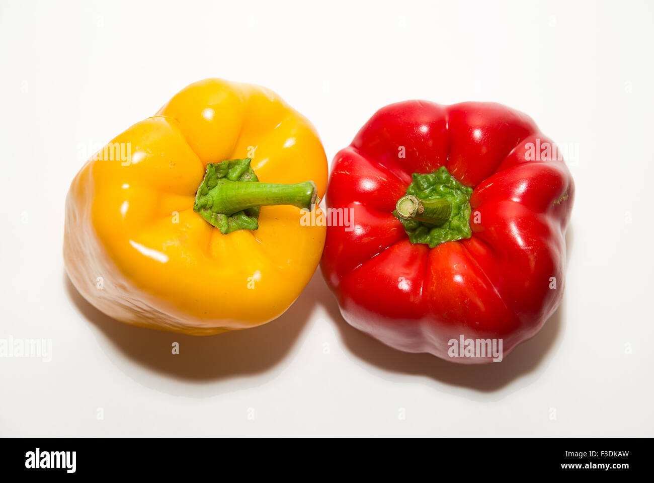 Two red and yellow peppers on a white background Stock Photo - Alamy
