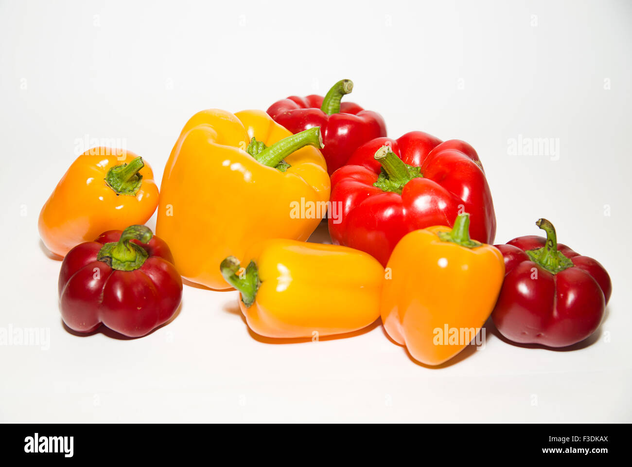 Many red and yellow peppers on a white background Stock Photo - Alamy