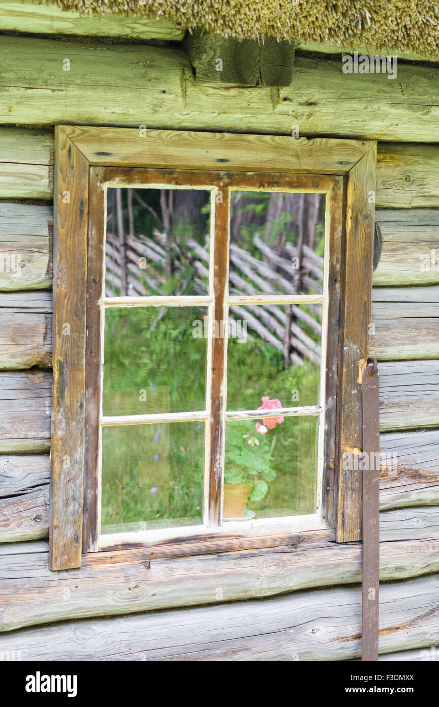 Window in old wooden rural house, courtyard reflection on glass Stock Photo