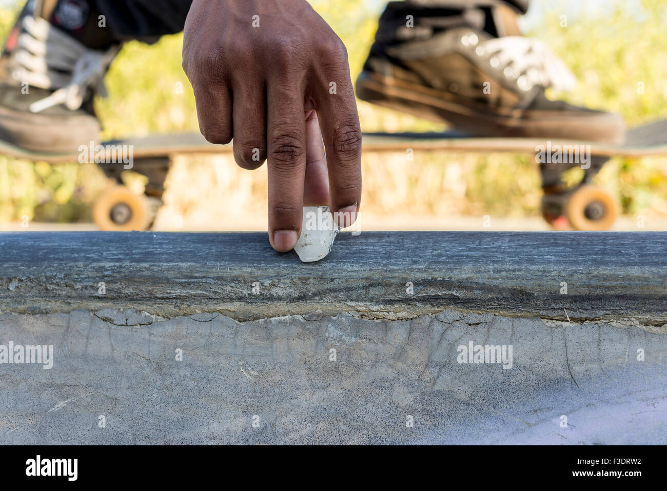 close up of skaters hand waxing rail so the skateboard can slide easier on  rail Stock Photo - Alamy