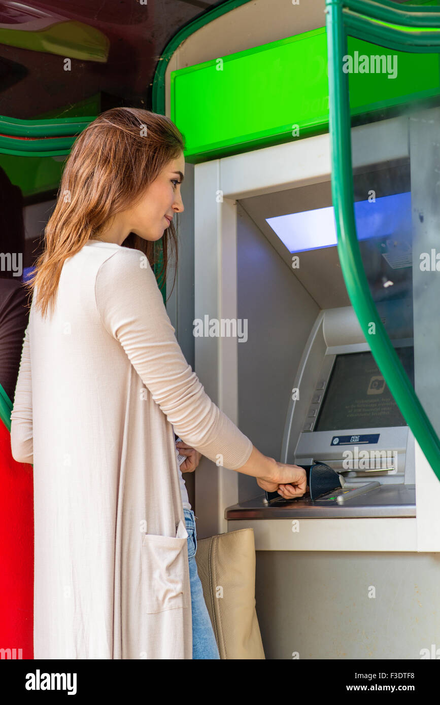 Young pretty woman at the ATM machine Stock Photo