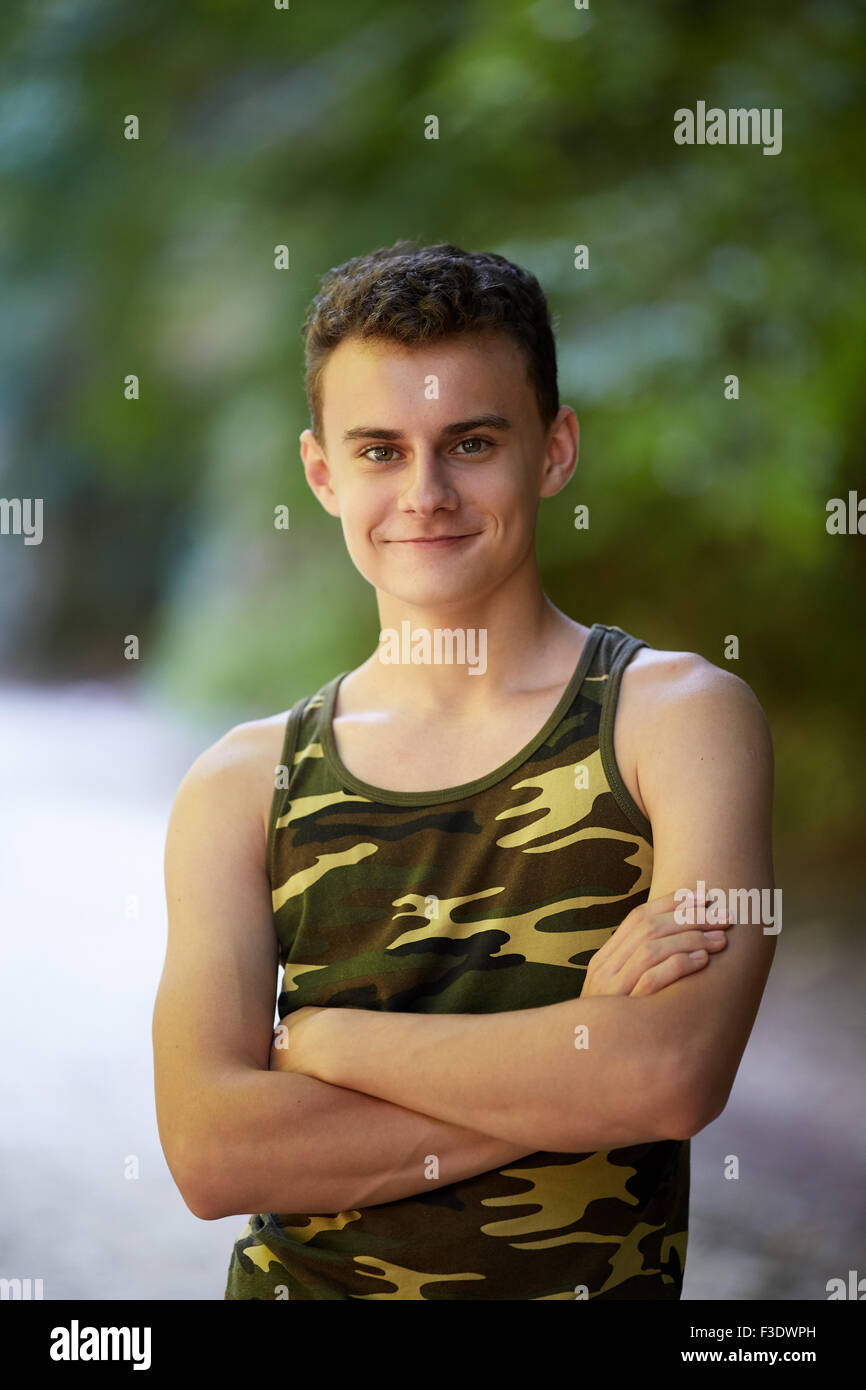 Handsome teenage boy with folded arms outdoor Stock Photo - Alamy