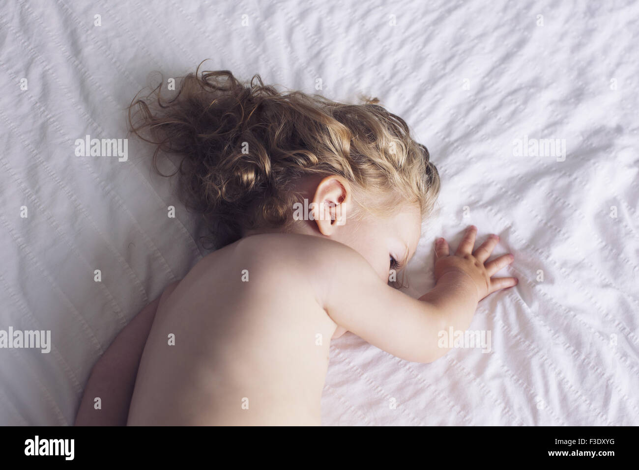 Baby girl napping on bed Stock Photo