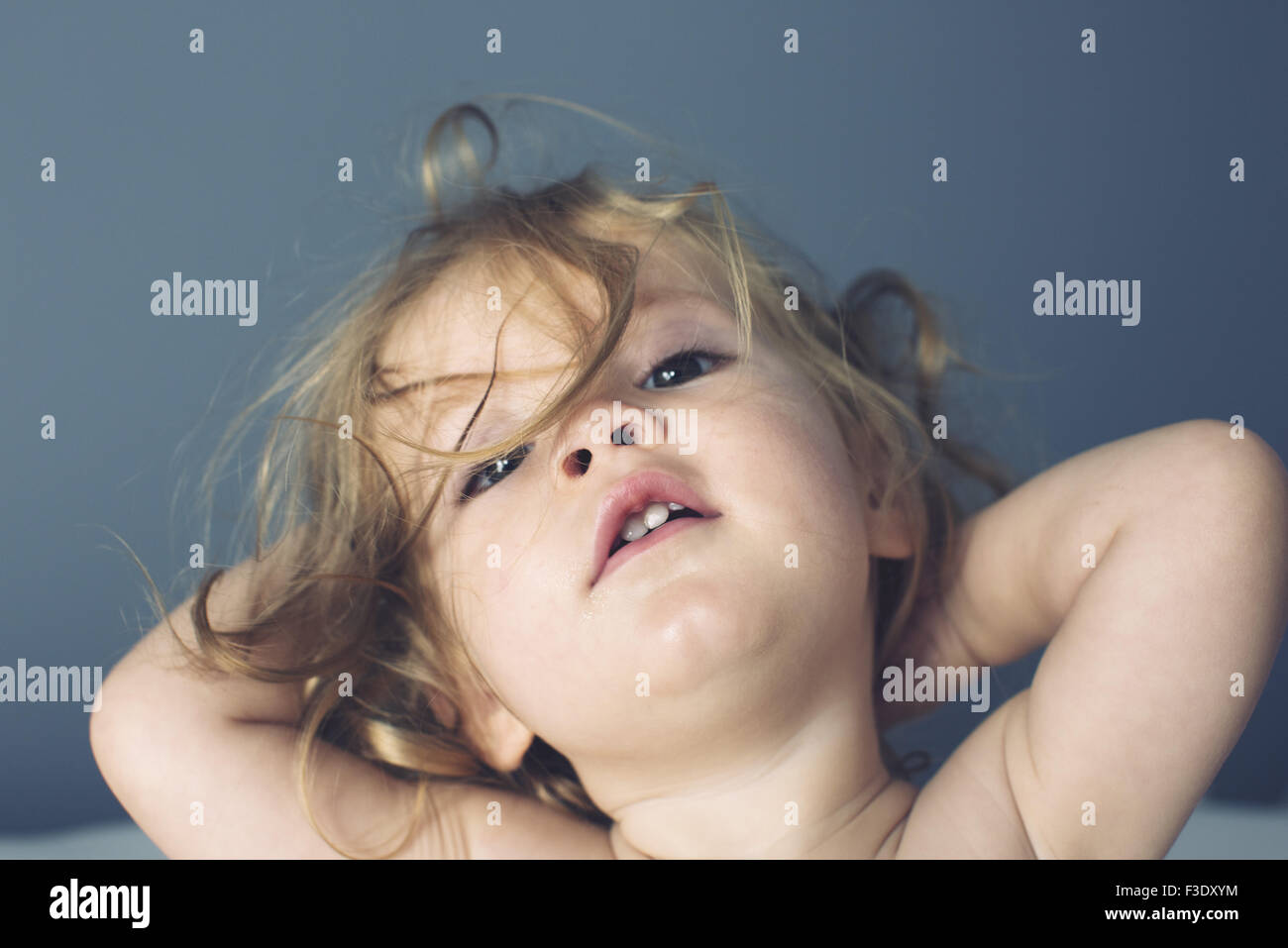 Baby girl with hands behind head, portrait Stock Photo