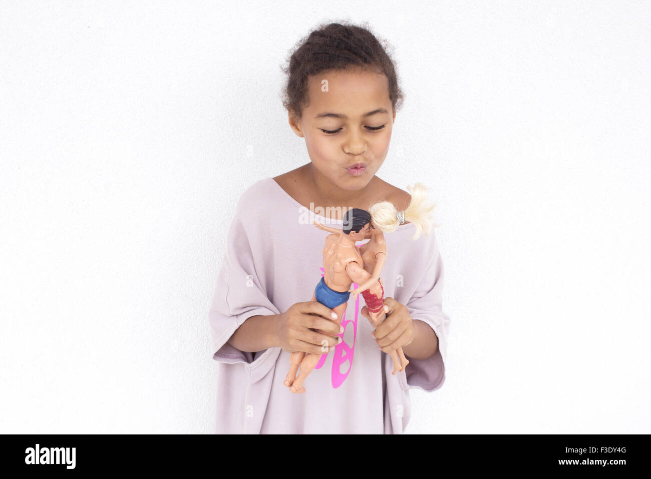 Girl making dolls kiss each other Stock Photo
