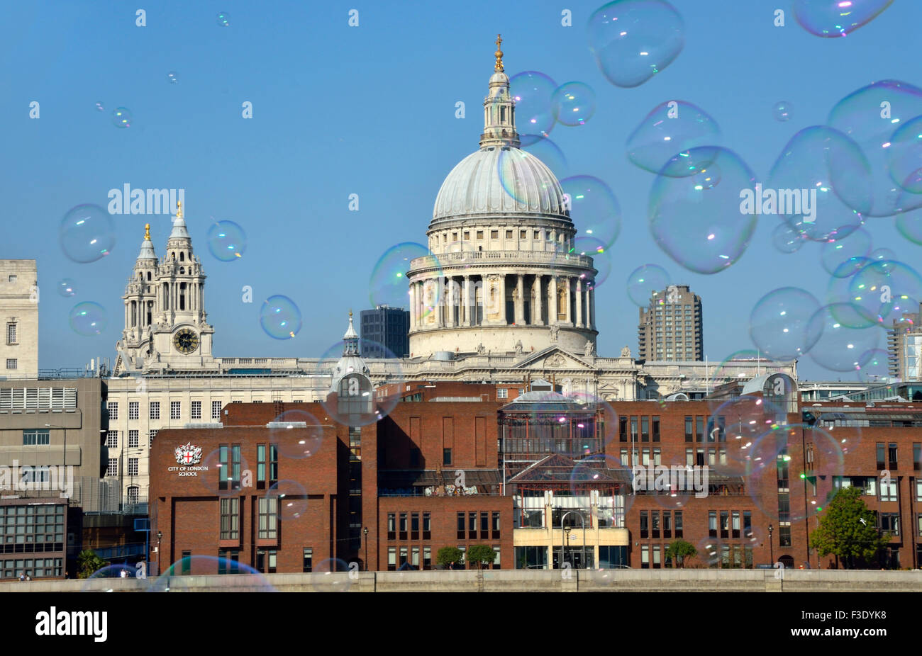 London, England, UK. Large bubbles floating past St Pauls Cathedral, made by a street entertainer on the South Bank Stock Photo