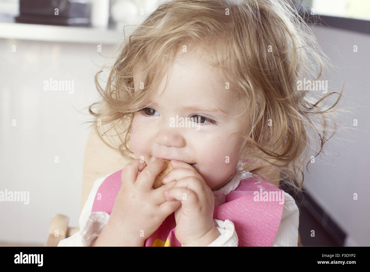 Baby girl eating snack, portrait Stock Photo