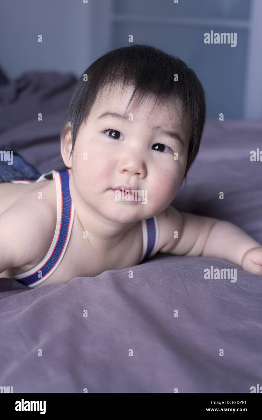 Baby lying on stomach on bed, portrait Stock Photo Alamy