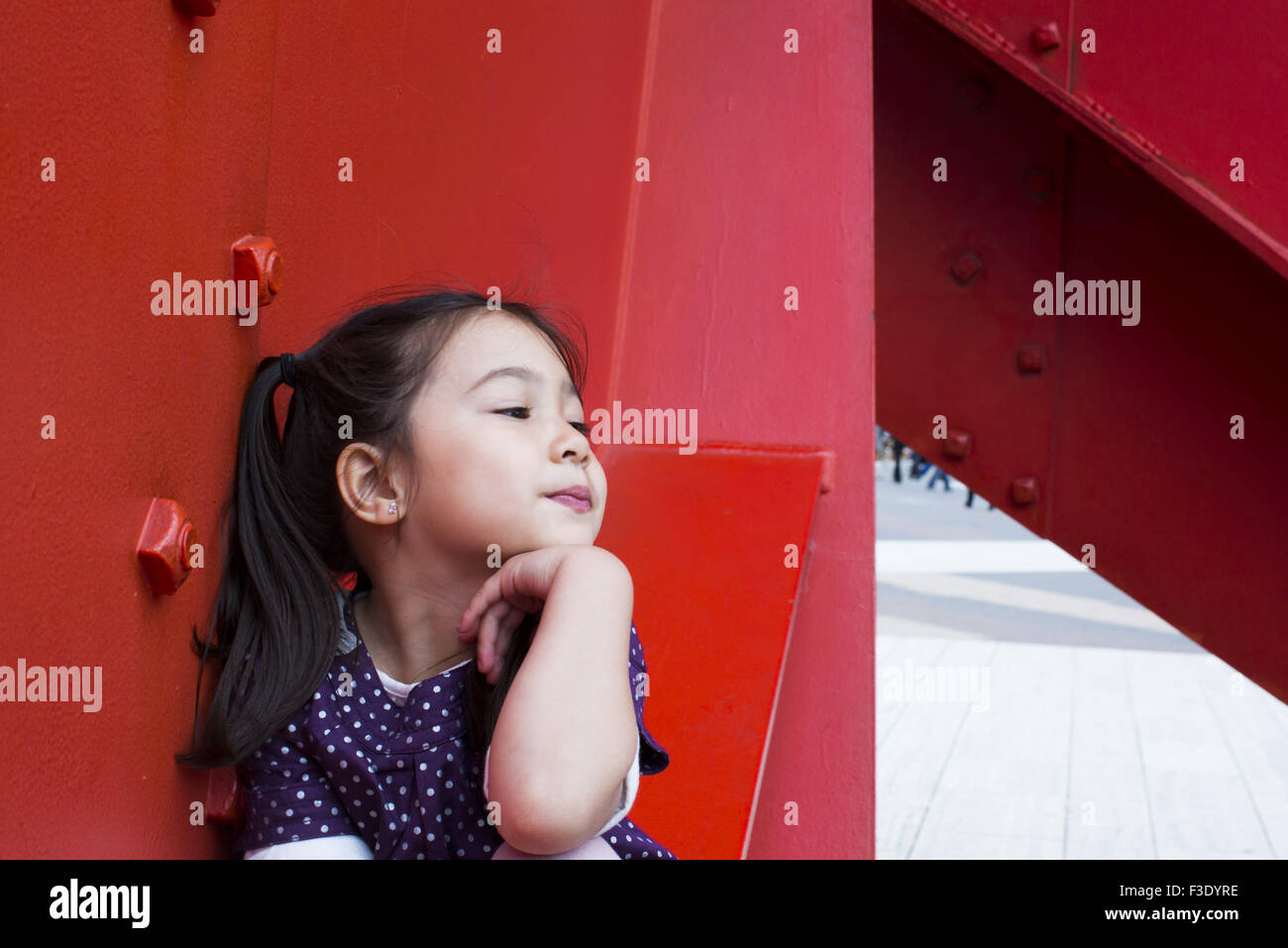 Little girl with hand under chin daydreaming Stock Photo