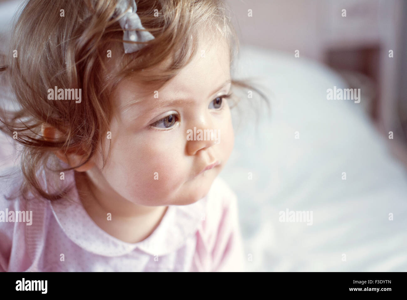 Baby girl looking away in thought, portrait Stock Photo
