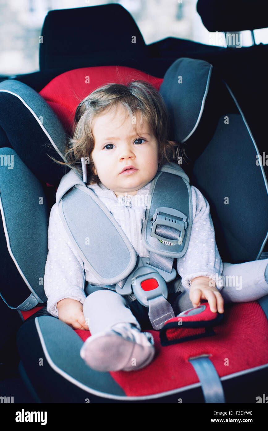Baby girl sitting in car seat Stock Photo