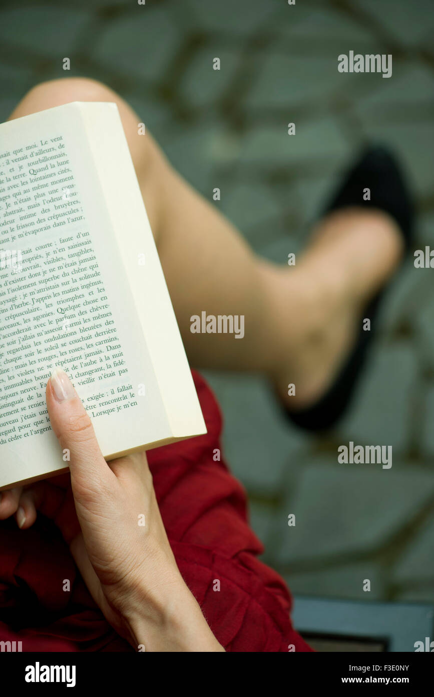 Woman reading book, over the shoulder view Stock Photo