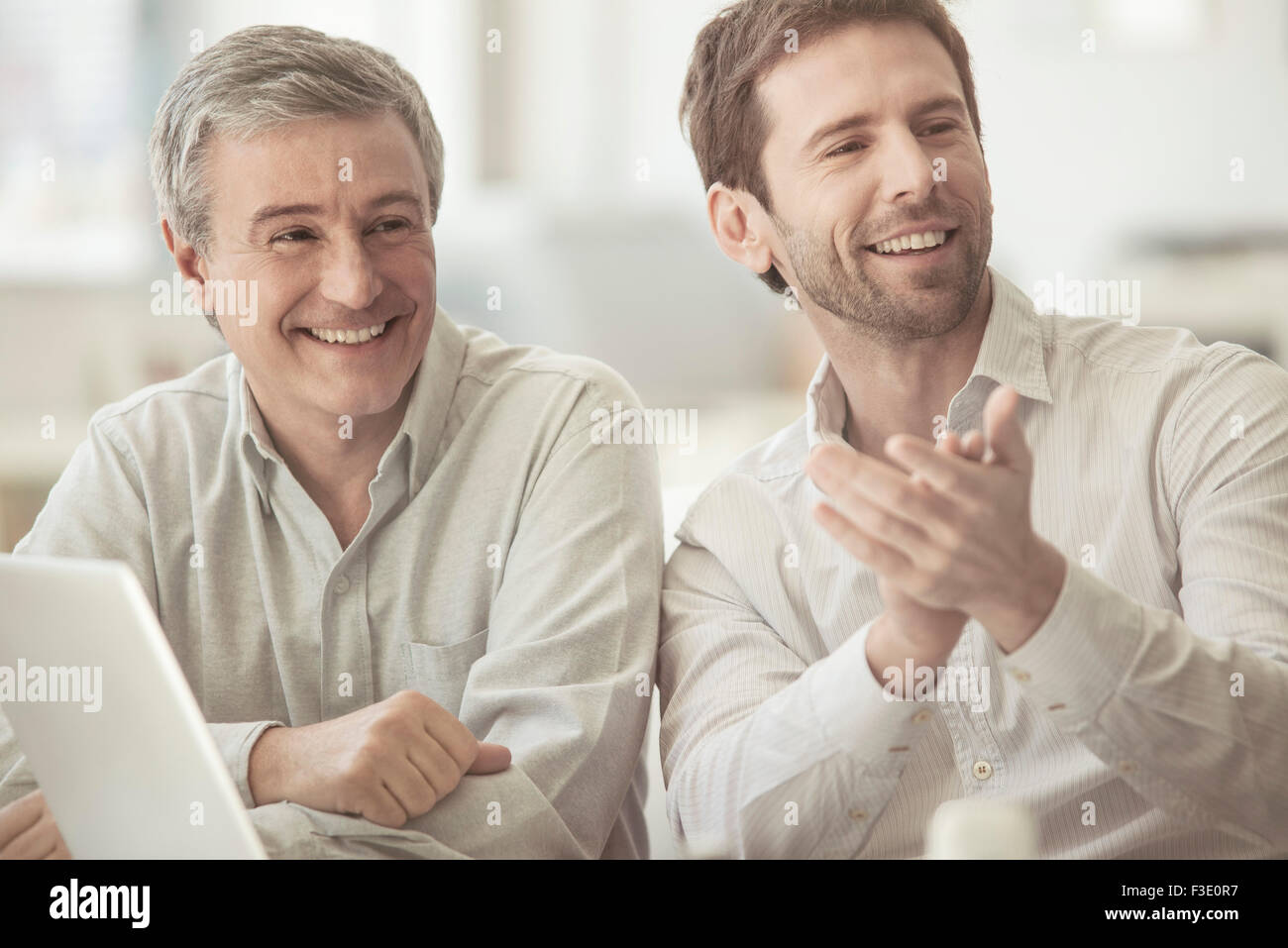 Colleagues smiling and clapping Stock Photo