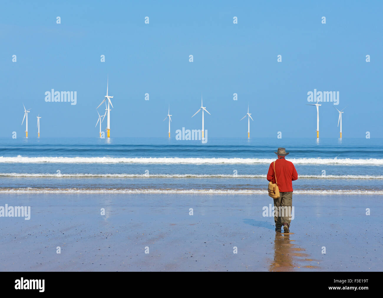 Man walking on the beach at Redcar, Cleveland, England UK Stock Photo