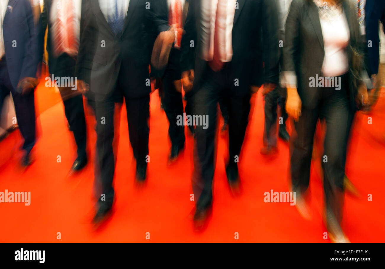 People in suits walking on red carpet. Stock Photo