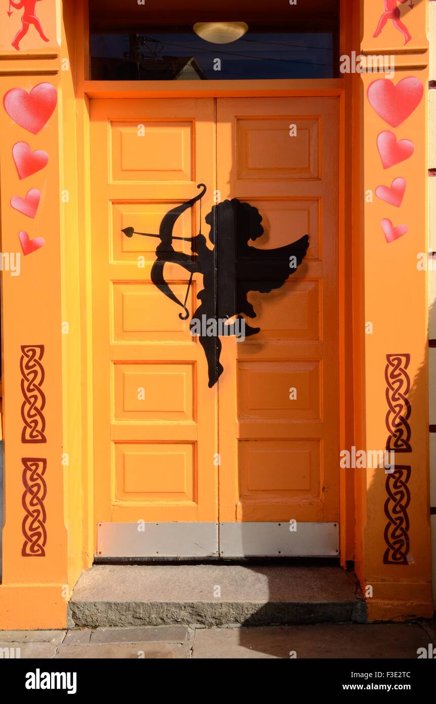 Cupid on a bright orange door of The Matchmaker Bar Lisdoonvarna County Clare Ireland Stock Photo