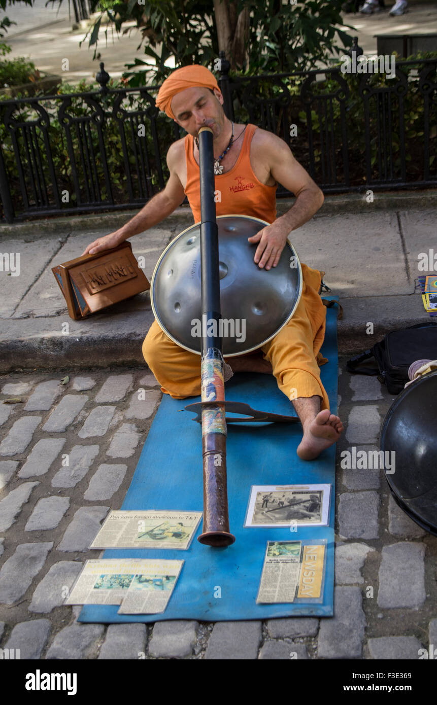 Street performer playing der Hang and a harmonium at the same time as a didgeridoo on the island republic of Cuba Stock Photo