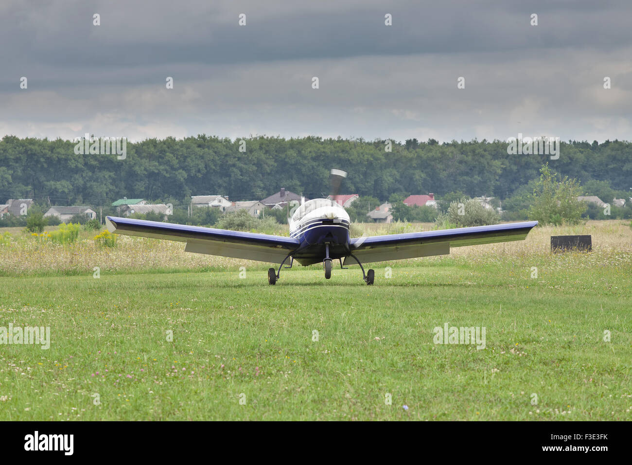 Small private plane touching down under the stormy clouds Stock Photo